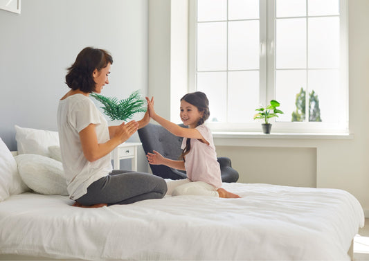 little girl playing on bed with mother